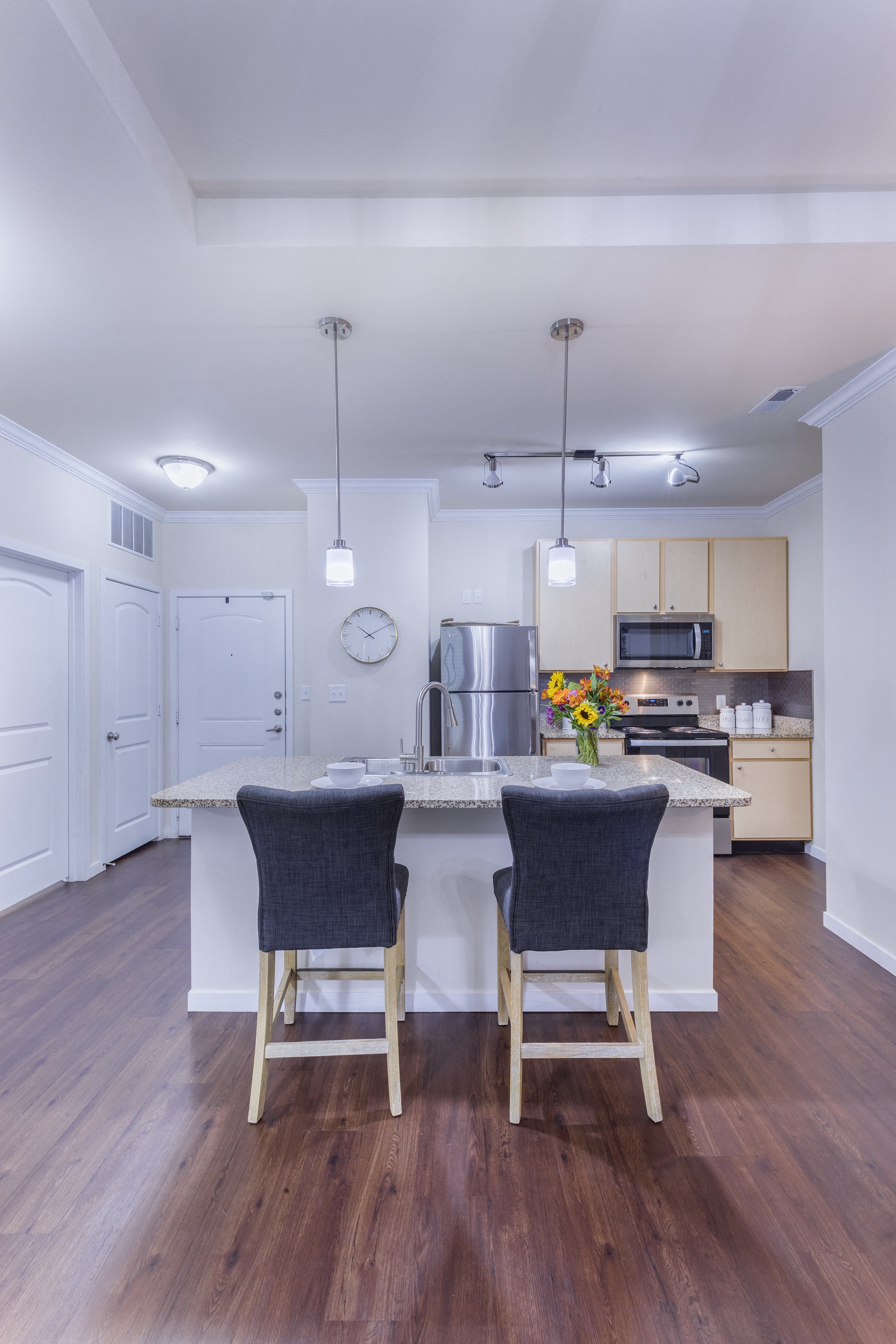 a kitchen with a large island with two chairs in front of it at Aventura at Forest Park, St. Louis, MO 63110